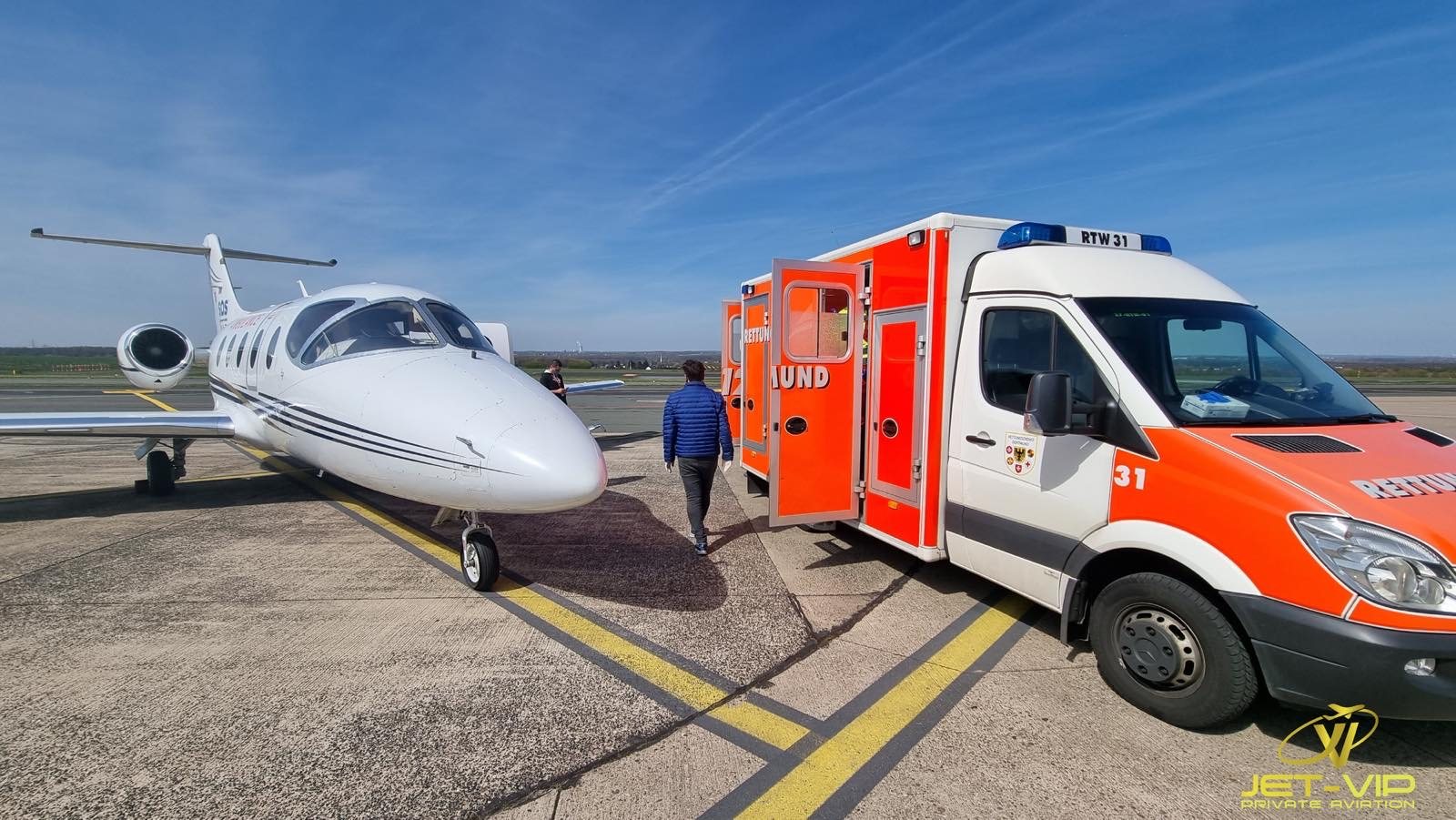 Équipe médicale Ambulance Flight sur le tarmac auprès de l'avion-ambulance, illustrant un rapatriement sanitaire depuis l'Espagne