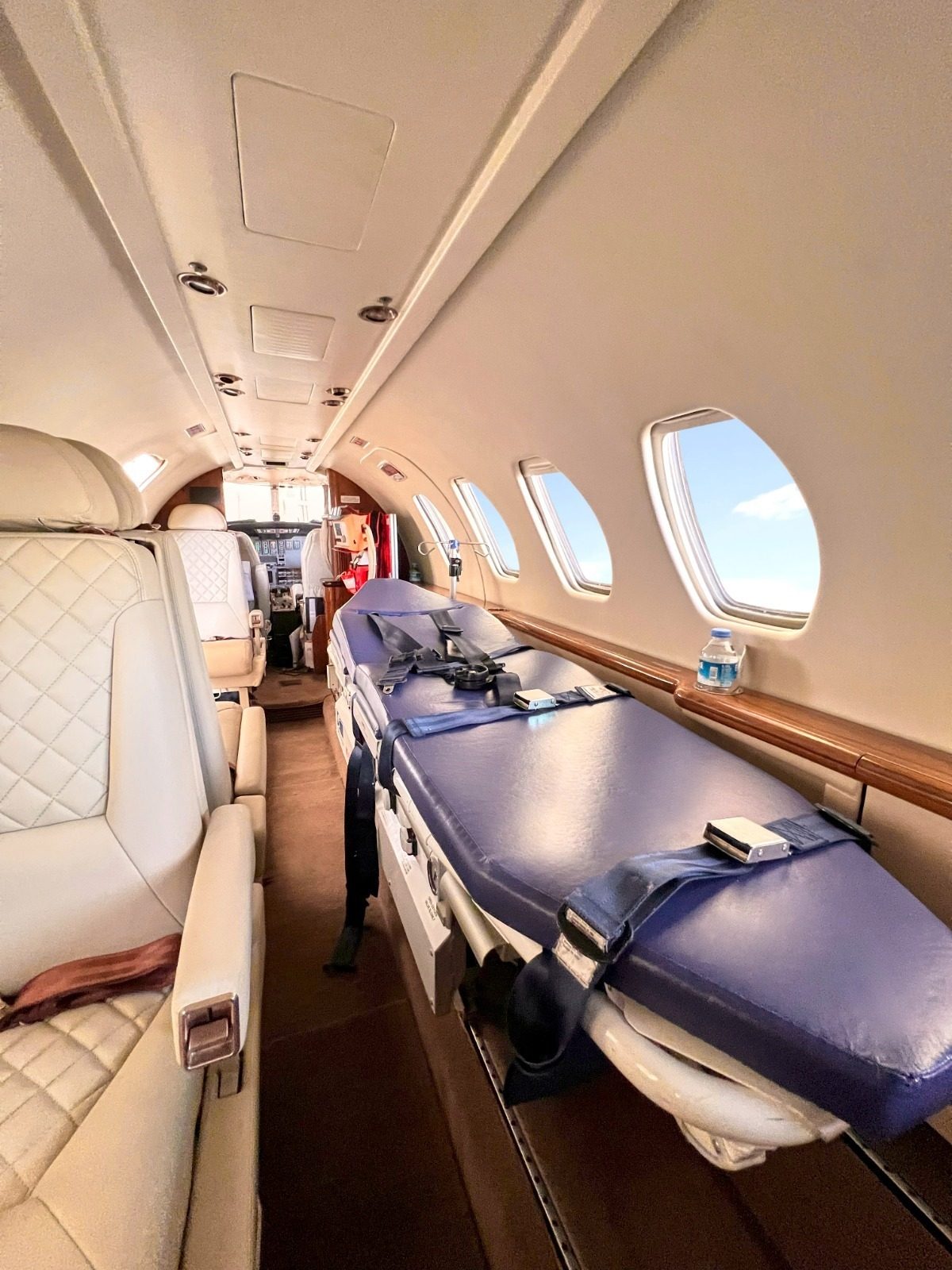 Cabine d'avion-ambulance avec civière médicale et sièges, prête pour un transfert bed-to-bed