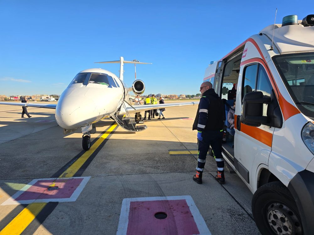 Équipe médicale Ambulance Flight préparant le matériel de transport auprès de l'avion-ambulance, illustrant un rapatriement sanitaire depuis le Portugal