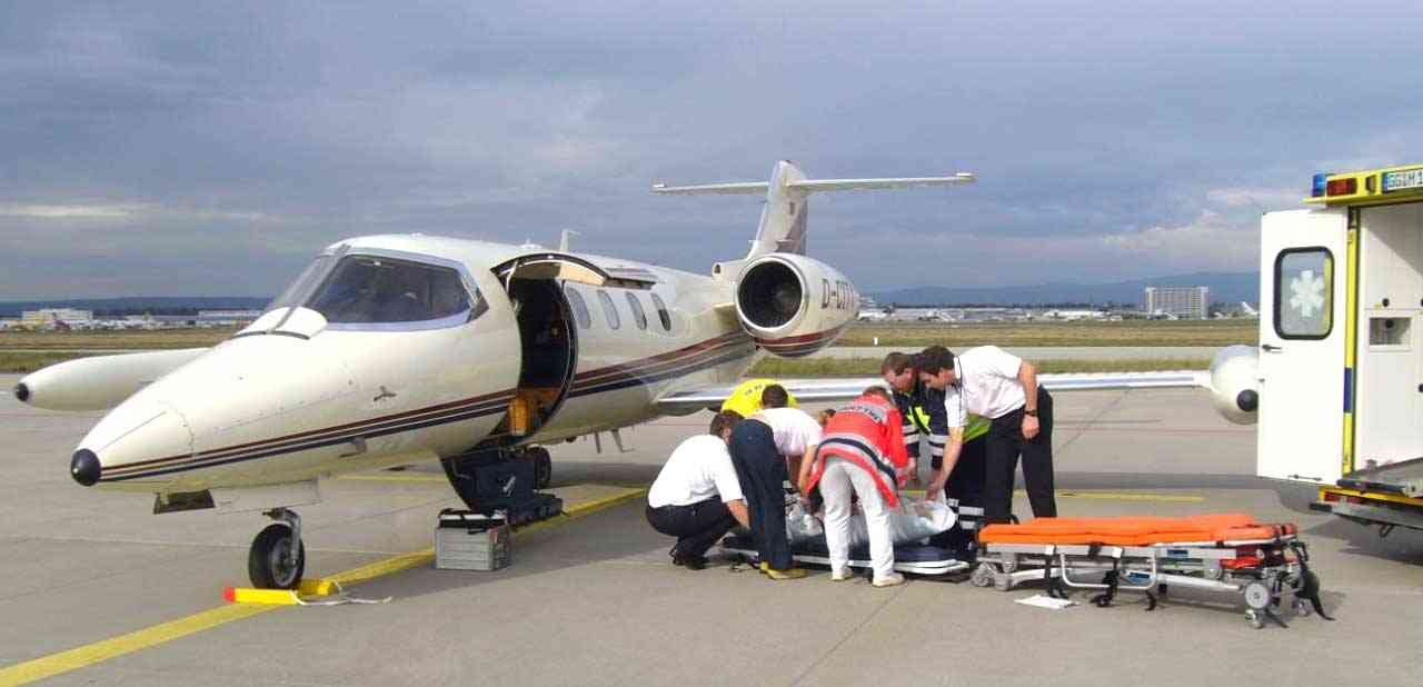 Pistte bir hastayı transfer eden Learjet hava ambulansı ve kara ambulansı ekibi — Gabon ve Fransa Arasında Tıbbi Repatriasyon