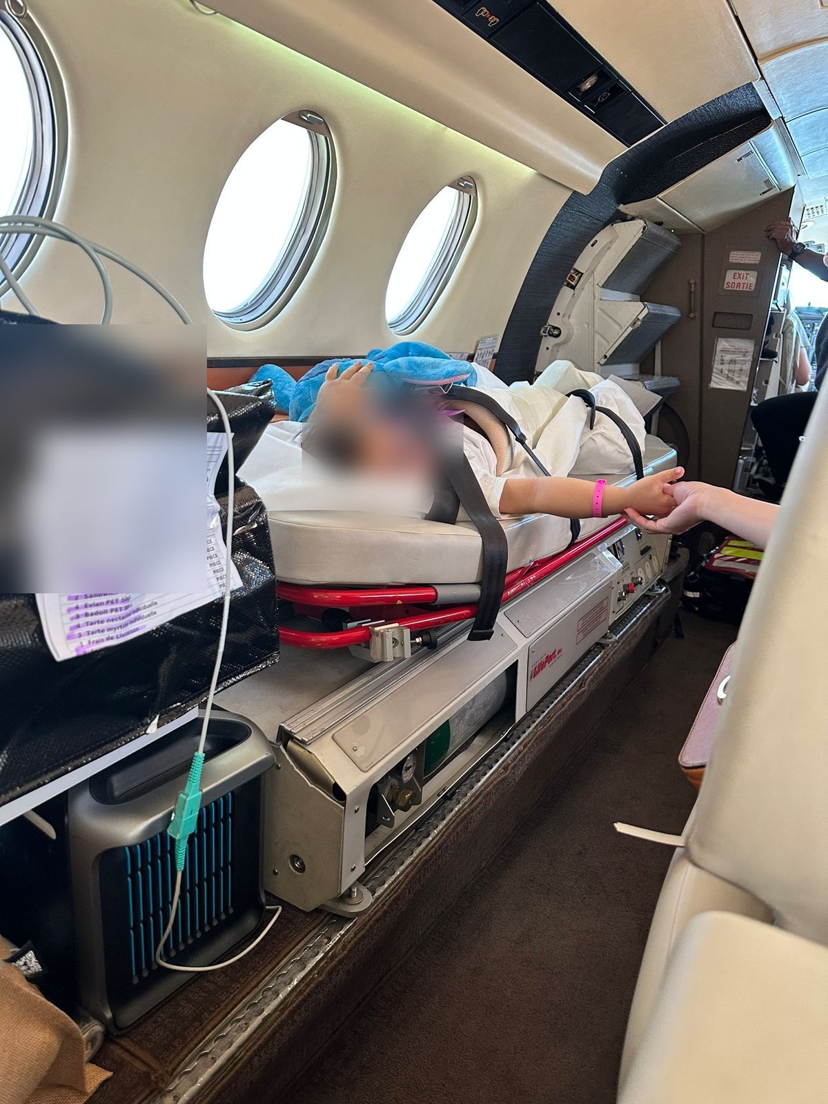 Medical crew member caring for a young patient during an air ambulance mission