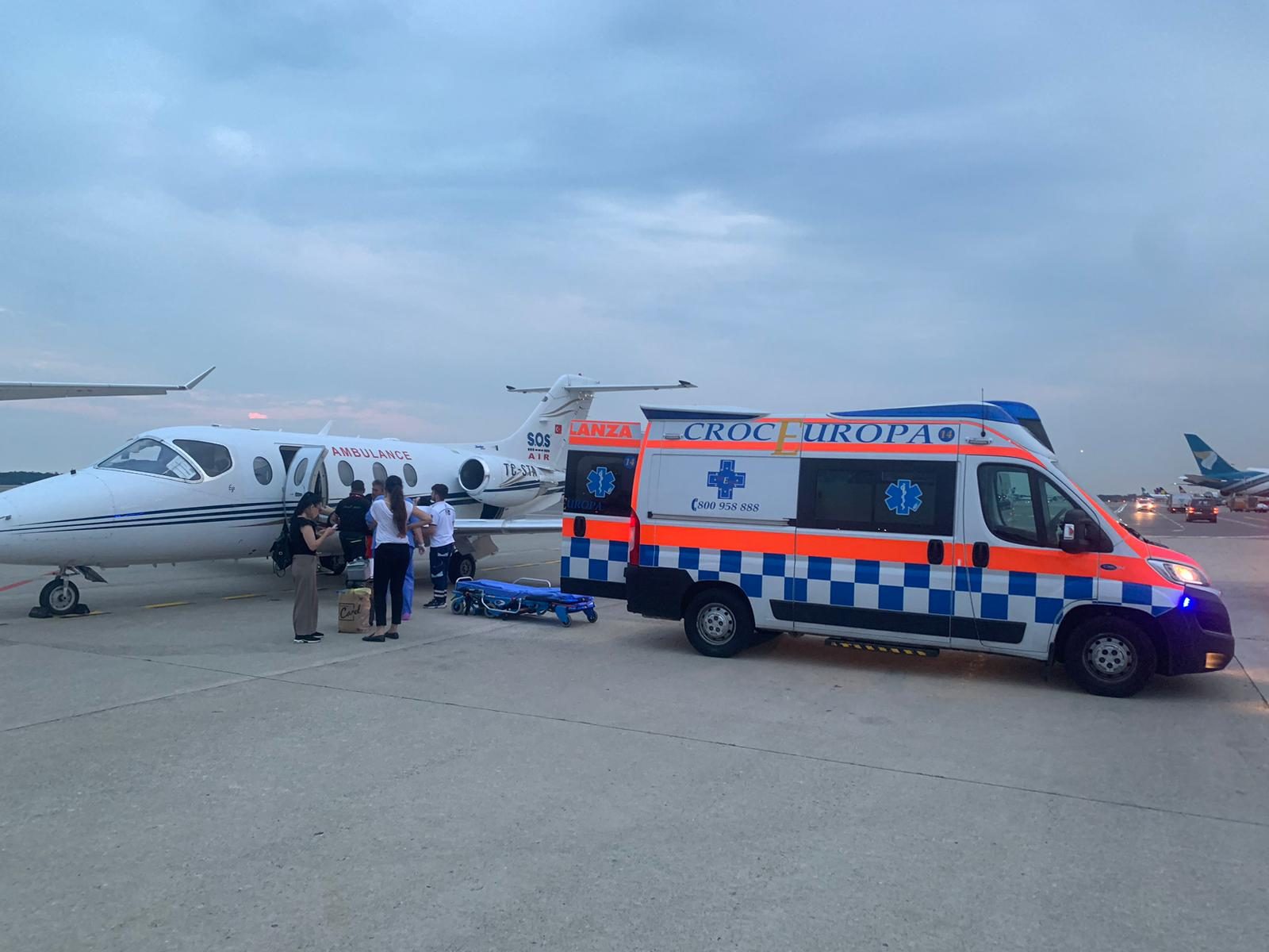 Avion Ambulance Flight et ambulance terrestre sur le tarmac au crépuscule, prêts pour une mission d'évacuation sanitaire