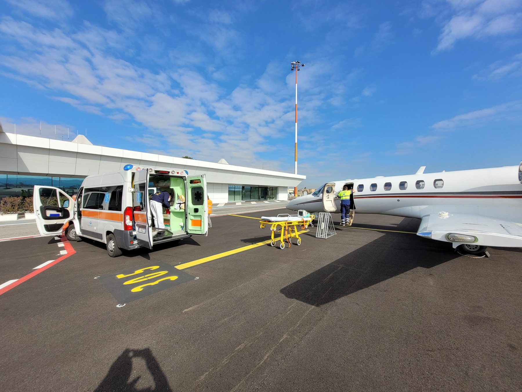 Équipe d'ambulance terrestre transférant un patient vers un avion-ambulance sur le tarmac
